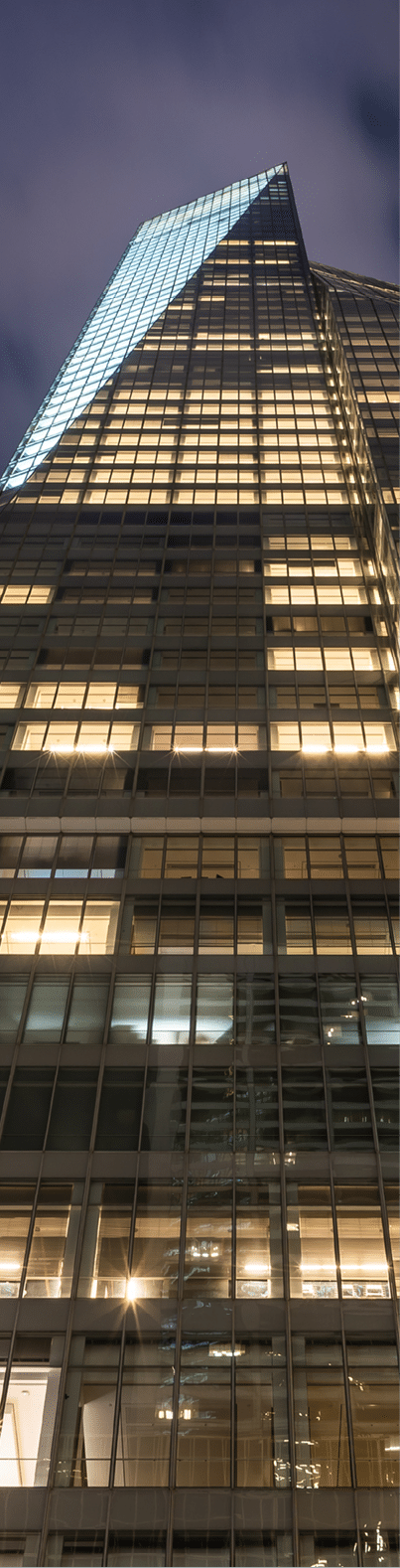 This upward looking view from Sixth Avenue in midtown Manhattan looks up at the Bank of America Tower  Also seen here is the Salesforce Building with the spotlights on the roof  Sixth Avenue in midtown is lined with tall office buildings and close proximity to Bryant Park, Times Square, Rockefeller Center and Central Park 