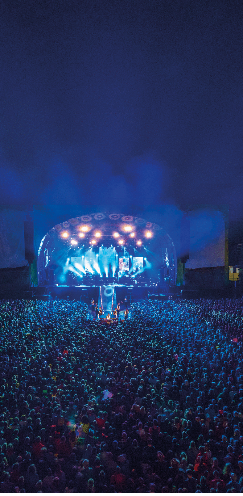 Crowd watching a band perform at summer music festival, UK 