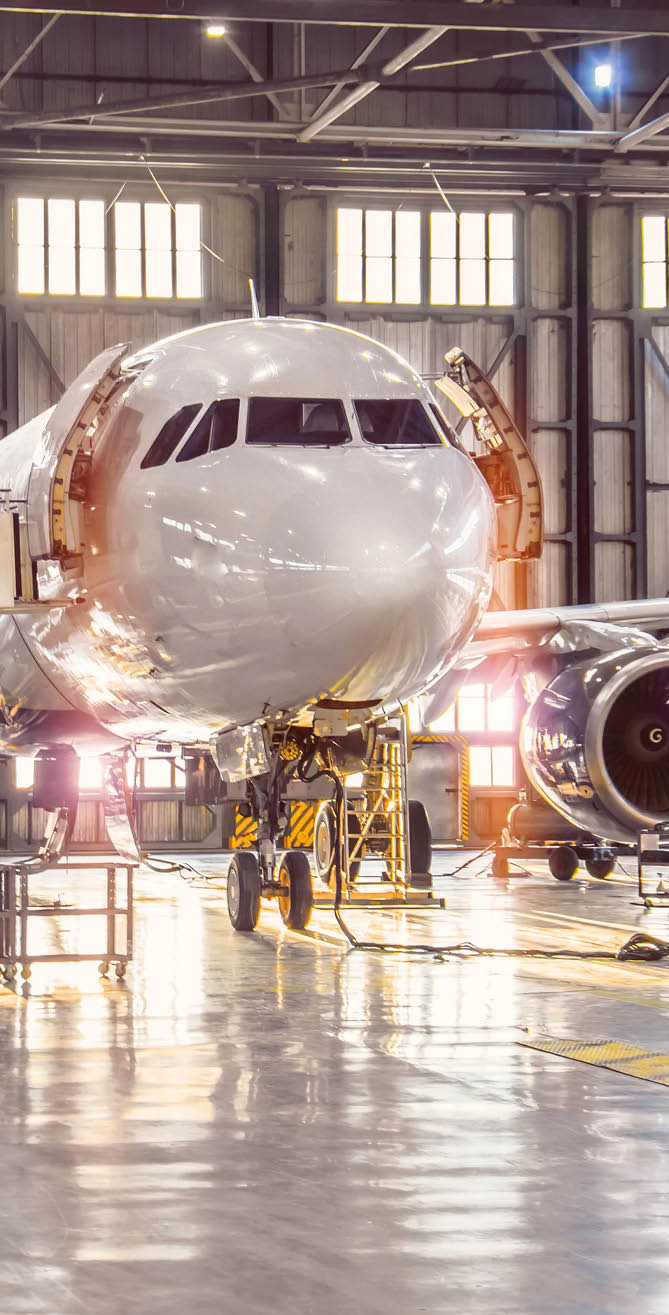 Large-scale inspection of all aircraft systems in the aircraft hangar by worker mechanics and other specialists  Bright light outside the garage door