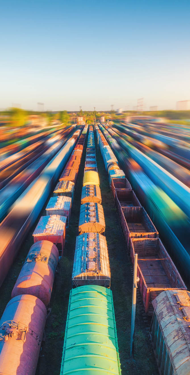 Aerial view of colorful freight trains at sunset  Cargo wagons with goods on railway station  Railroad  Heavy industry  Industrial landscape with railway platform  Top view from drone of depot  Urban